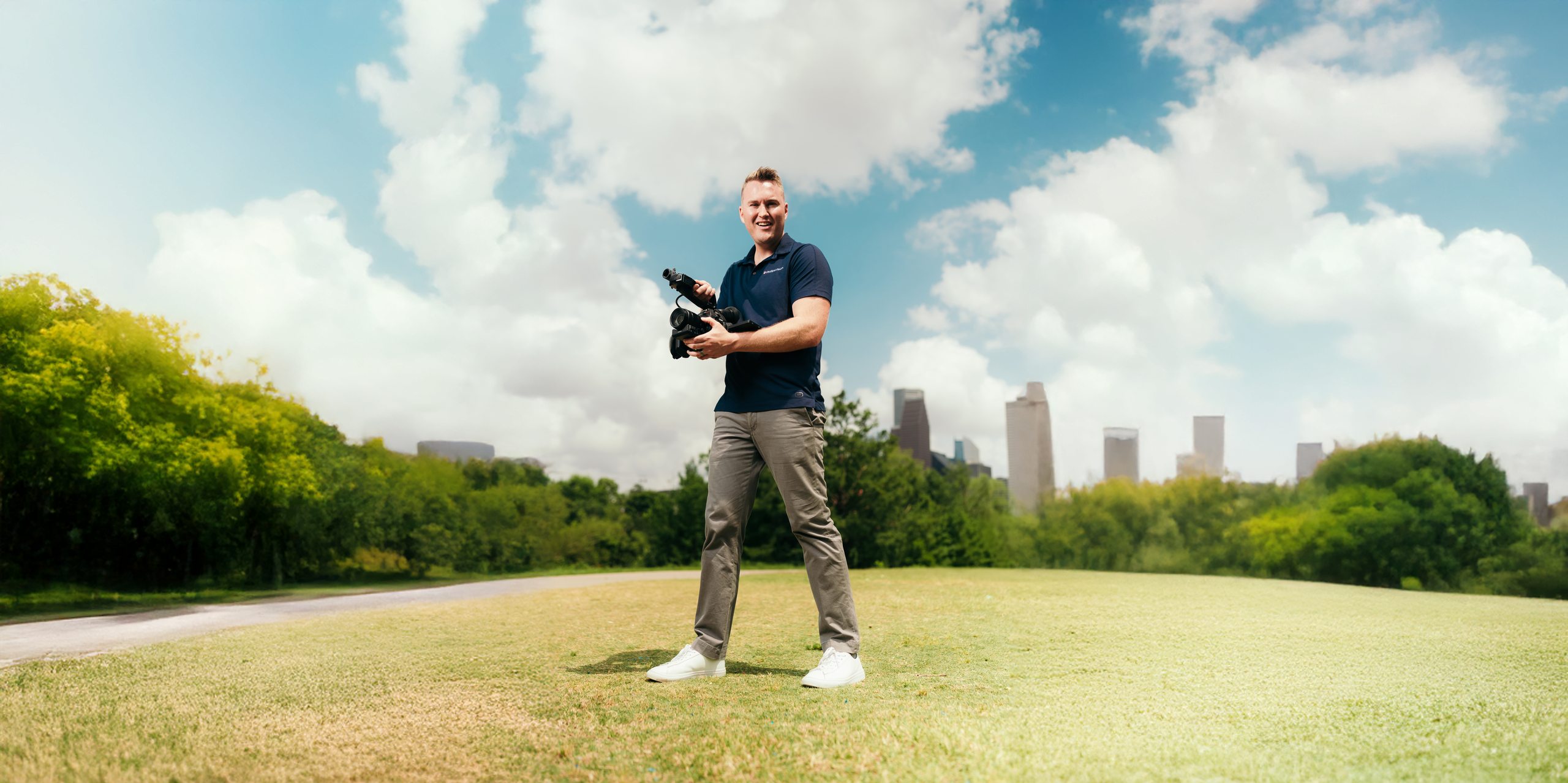 Travis Phillips with his
    cinema camera in front of the Houston skyline